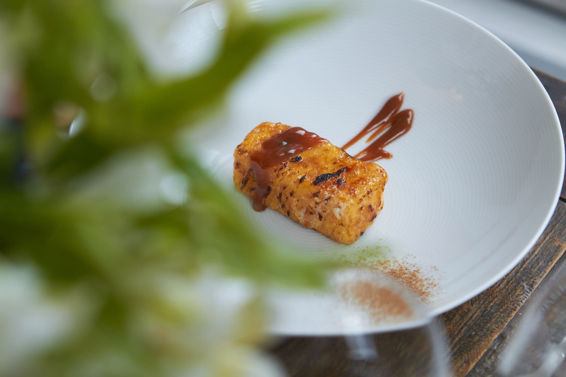 Prato grelhado com calda, servido em mesa de restaurante.