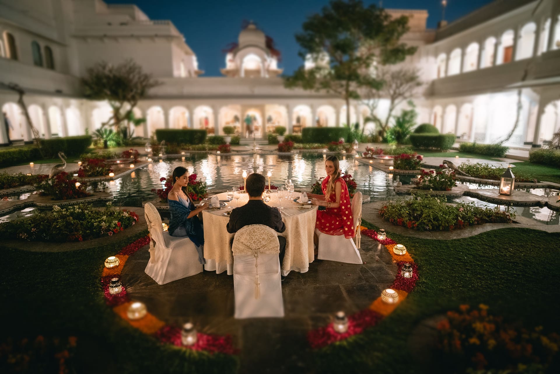 Jantar em circulo montado num patio de palacio, velas no chao.