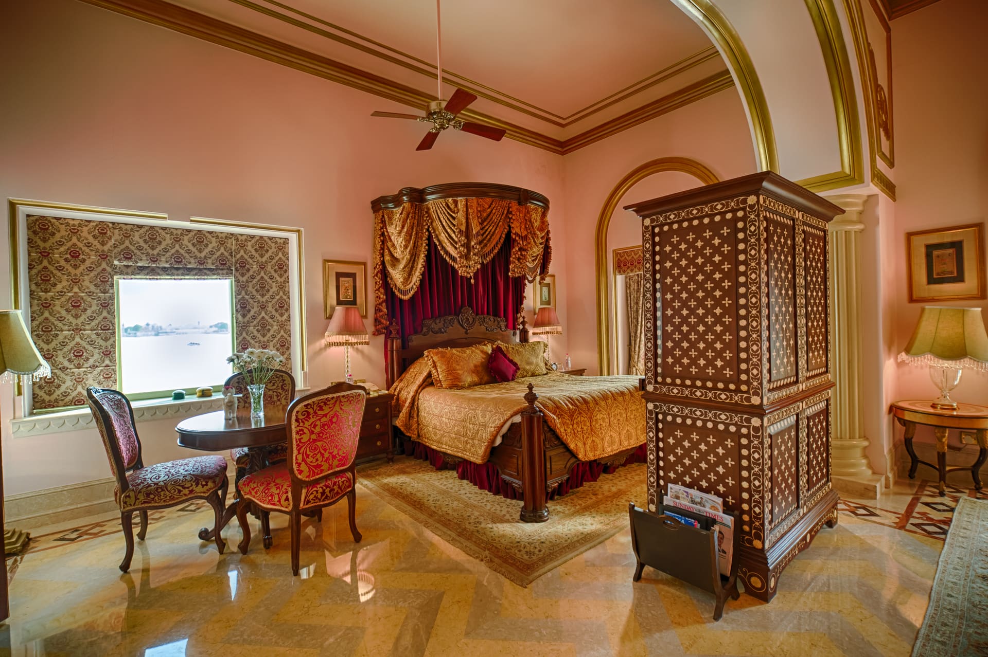 Suite de palacio com dossel e teto trabalhado.