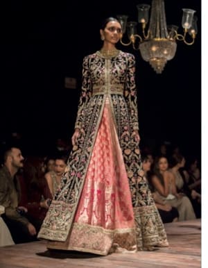 Lehenga bordada de Sabyasachi na passarela cercada de livros.